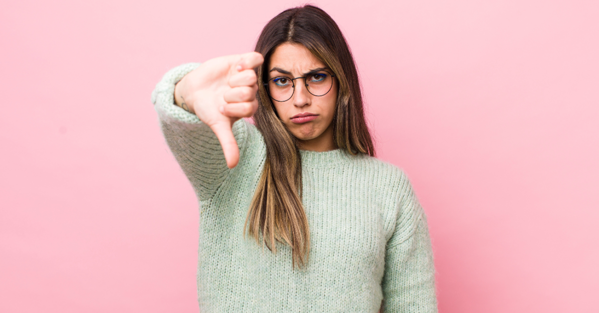 Persona enfadada con pulgares hacia abajo