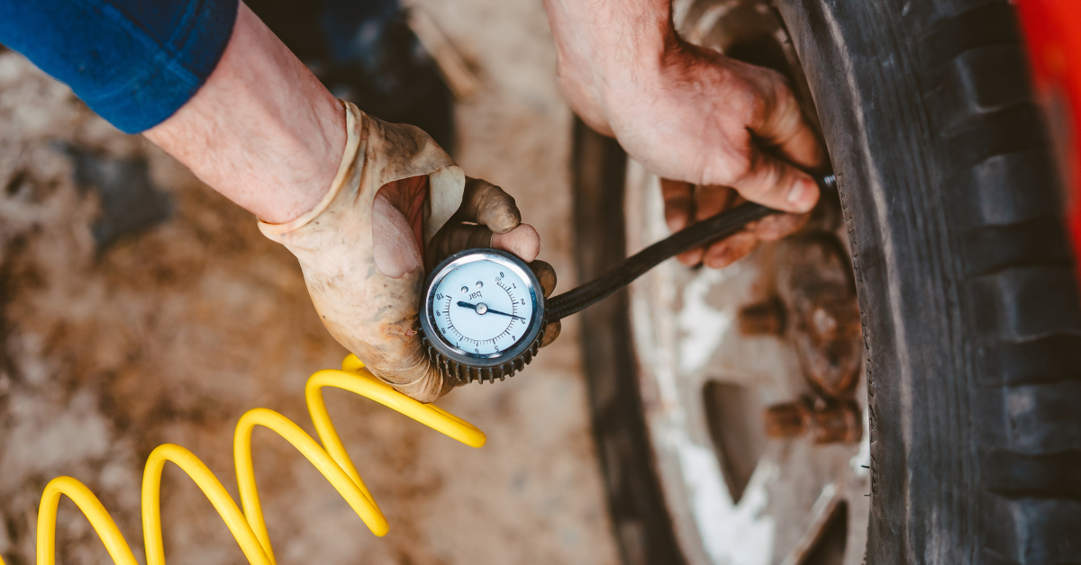 Persona midiendo presión de las ruedas