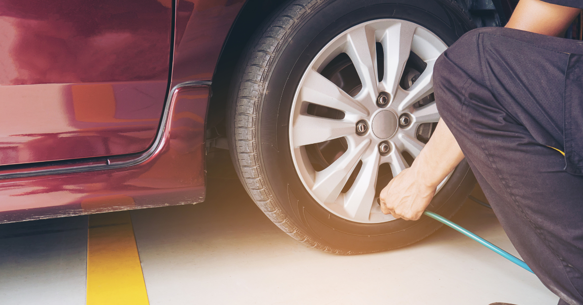 Persona midiendo presión de las ruedas del coche