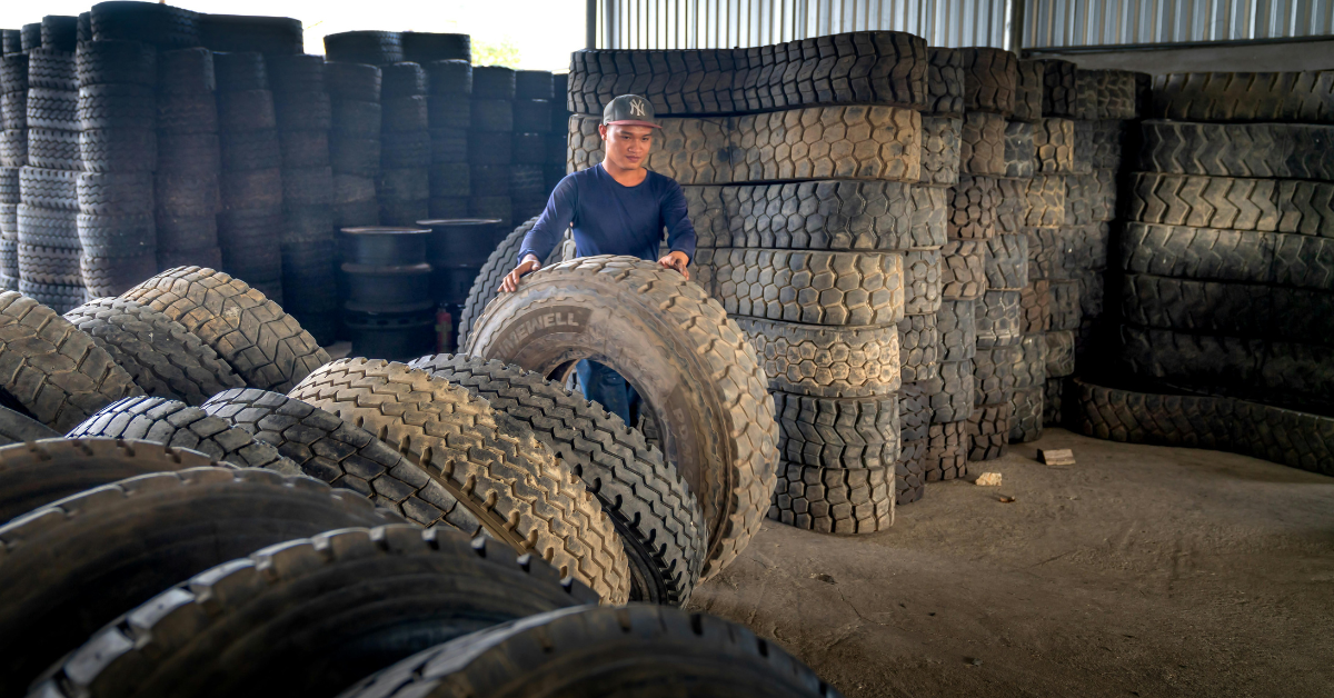 Hombre ordenando neumáticos de gran tamaño
