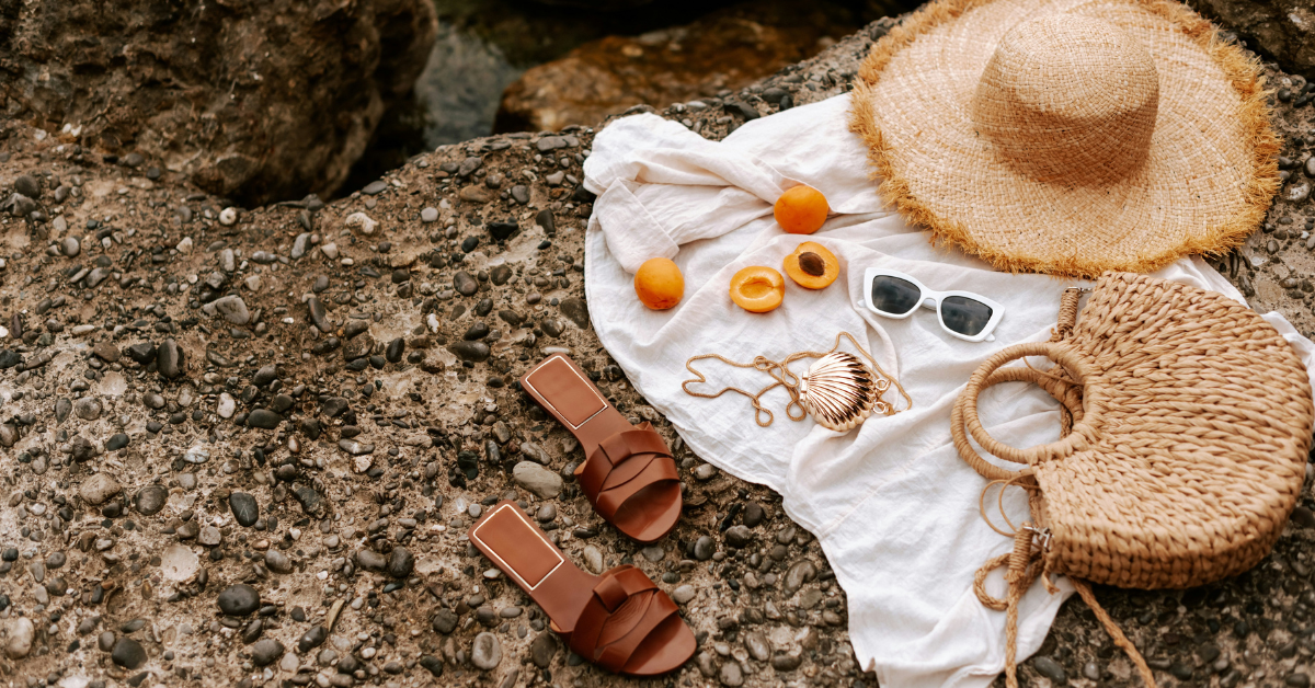 Bolsa de playa y sombrero en roca de la playa
