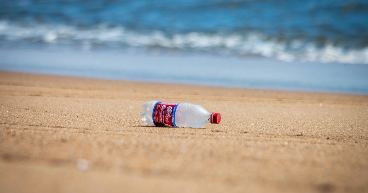 Botella de plástico tirada en la playa