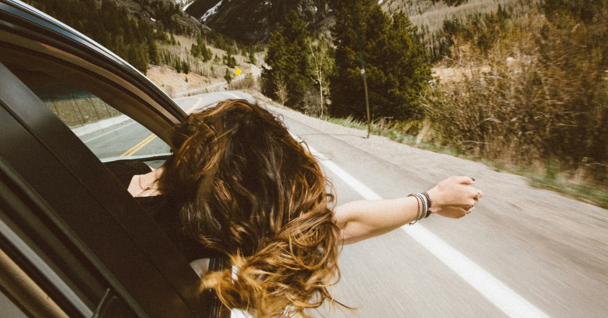 Chica asomada por ventanilla del coche
