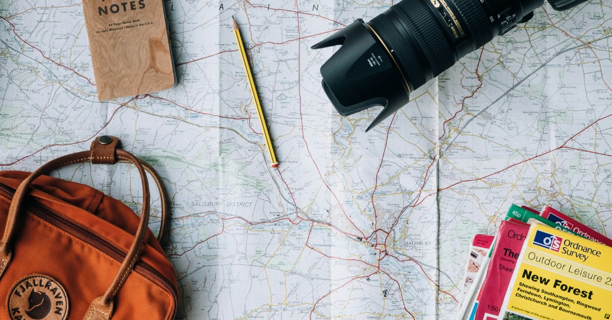 Mapa de viaje con mochila, lápiz, cámara y libreta de notas
