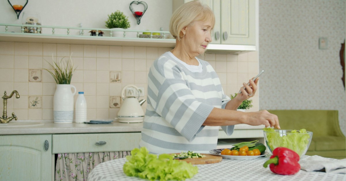 Mujer cocinando mientras mira el móvil