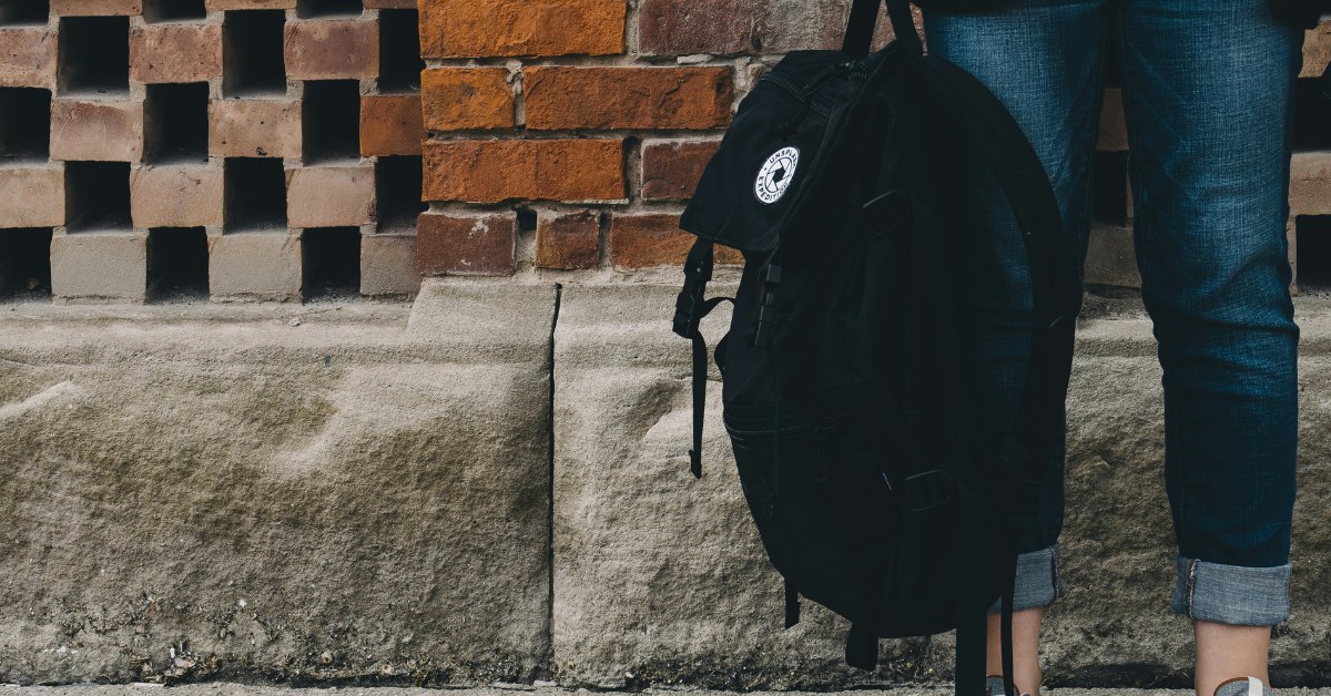 Mujer joven sosteniendo mochila