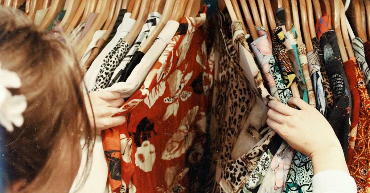 Mujer eligiendo ropa en perchas